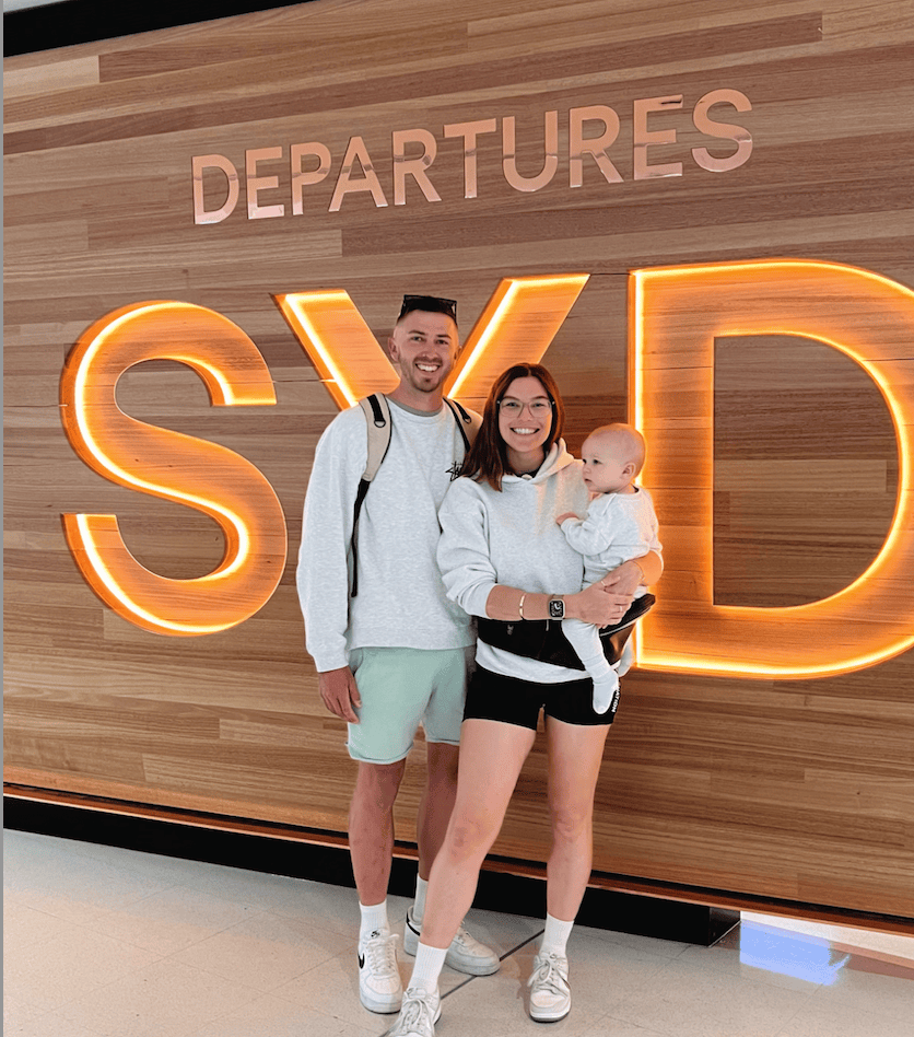 Parent carrying toddler through the airport in the HipSurfer travel baby carrier